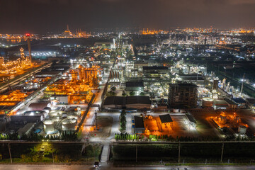 Fototapeta na wymiar Aerial view of petrochemical oil refinery and sea in industrial engineering concept in Bangna district at night, Bangkok City, Thailand. Oil and gas tanks pipelines in industry