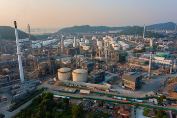 Aerial view of petrochemical oil refinery and sea in industrial engineering concept in Bangna district at night, Bangkok City, Thailand. Oil and gas tanks pipelines in industry