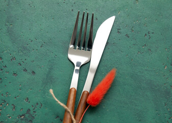 Knife and fork with floral decor on green background