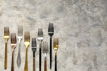 Many different forks on light background, top view