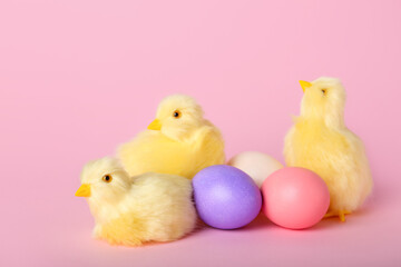 Cute yellow chickens and Easter eggs on pink background