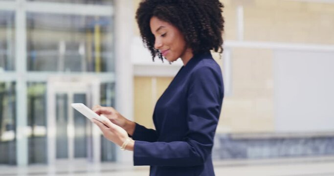 Technology opens a whole world of possibilities. Businesswoman using a digital tablet in the workplace. Young worker with an afro using a smart device while taking a break from the office 