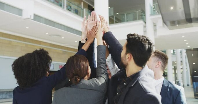 We are stronger when we stand together. 4k video footage of a group of businesspeople giving each other a high five in an office.