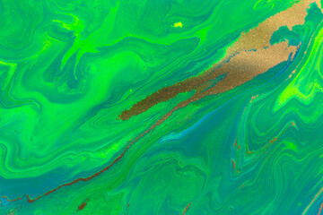 Gold spots on flow green paints background. Abstract green print