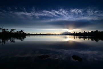 Beautiful sunset cloudscape over Pine Glades Lake in Everglades National Park, Florida reflected in lake's calm water.