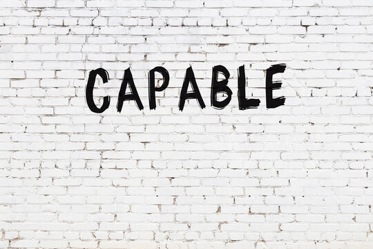 White wall with black paint inscription capable on it