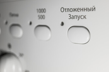 Button to turn on the function of delayed start of washing. Control panel of the washing machine. Russian interface. Selective focus. Text to translate Russian - Delayed Startup