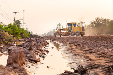 Road grader tractor working at road construction site, motor grader working on road construction