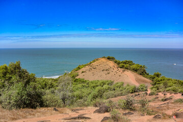 Panoramic view of beautiful blue Arabian Sea and a lush adjacent hill from the top of Chapora Fort, Goa India.