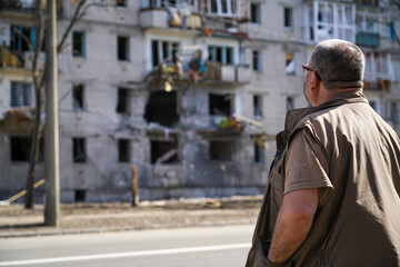 A man stands near a destroyed house that was hit by a shell from military operations in Ukraine