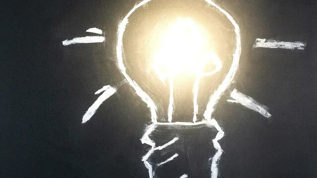 Lightbulb drawn in chalk on blackboard drawing light Bulb on black background