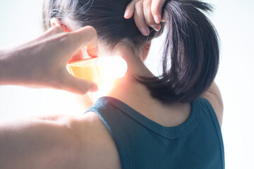 Overlight on Woman holding balm on neck. she neck pain due to strenuous exercise.generic home remedies for health concept. - obrazy, fototapety, plakaty