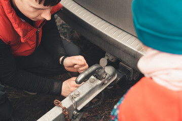 Man connects a trailer to the towbar of his car
