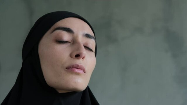 Close-up of a representative of the fair sex, a Muslim woman looking at the camera. She looks modest and frequent. Cruel rules in relation to women in Islam, the obligatory wearing of the hijab.