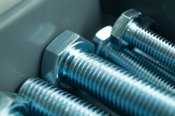 Large mounting bolts. New fasteners in the tool box. Metal bolt close-up. Selective focus