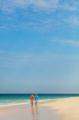 Fototapeta na wymiar Mature couple enjoying romantic vacation walking by ocean