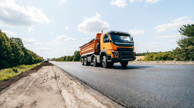 Dumper truck ready to unload soil or groud at construction site. Road service build a new highway	
