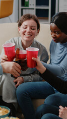 Coworkers clinking cups and bottles to enjoy leisure after work. Happy colleagues cheers with alcoholic beverage to celebrate party, having fun and entertainment after hours at office.