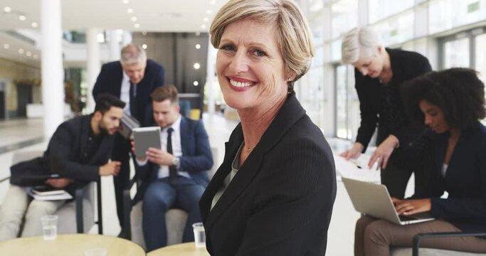 Shes sure of her abilities to succeed. 4k video footage of a businesswoman smiling in an office with her colleagues in the background.