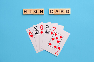High card combination. Poker Playing Cards on blue background with wooden blocks. Flatlay, copy space, concept