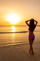 Fototapeta na wymiar Young Asian female watching sunrise on ocean horizon