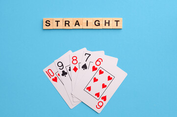 Straight combination. Poker Playing Cards on blue background with wooden blocks. Flatlay, copy space, concept