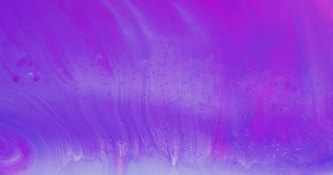 Floating paint. Iridescent background. Ink water mix. Defocused neon purple blue pink color bubble fluid flow motion abstract art texture shot on RED Cinema camera.