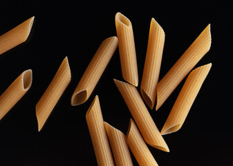 Dried pasta isolated on black background.