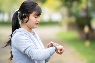 Attractive woman wearing wireless earphone before outdoor workout.Healthy lifestyle concept.