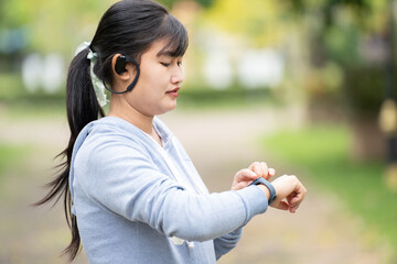 Attractive woman wearing wireless earphone before outdoor workout.Healthy lifestyle concept.