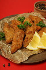 Concept of tasty food with chicken strips on red background