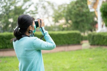 Woman is a professional photographer with  camera, outdoor and sunlight, Portrait, copy space.Beautiful woman taking picture outdoors