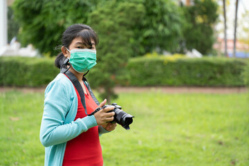 Woman is a professional photographer with  camera, outdoor and sunlight, Portrait, copy space.Beautiful woman taking picture outdoors