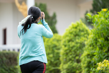 Woman is a professional photographer with  camera, outdoor and sunlight, Portrait, copy space.Beautiful woman taking picture outdoors