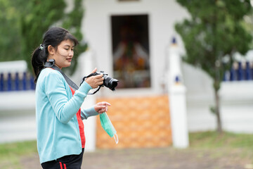 Woman is a professional photographer with  camera, outdoor and sunlight, Portrait, copy space.Beautiful woman taking picture outdoors