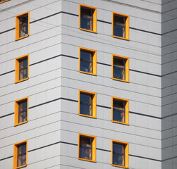 The walls of the building with yellow windows.