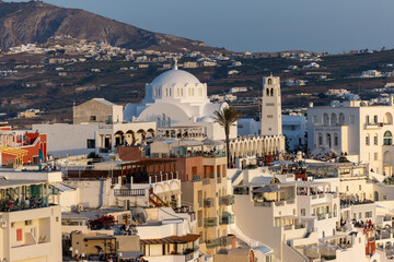  The whitewashed town of Fira in warm rays of sunset on Santorini island, Cyclades, Greece