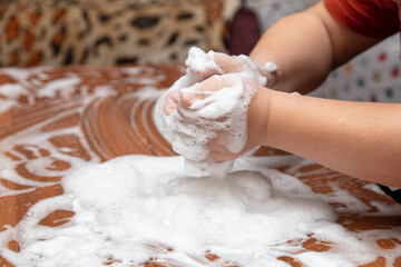 The boy plays with soap suds