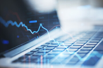 Close up of laptop with falling downword forex chart on blurry background. Crisis, stock and loss concept. Double exposure.
