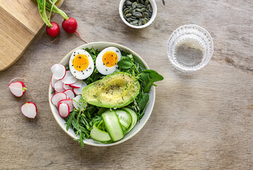 Healthy green salad with avocado and eggs.