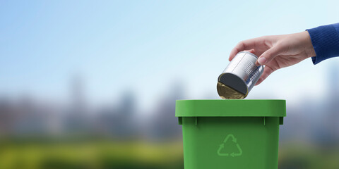 Woman putting a tin in the trash bin