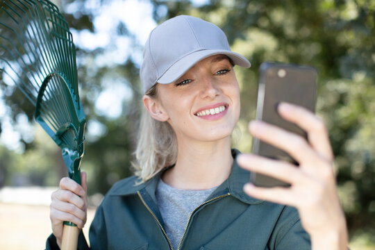 young caucasian gardener takes photo with smartphone
