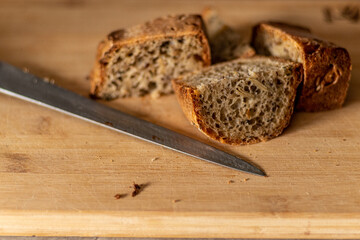czerstwy chleb razowy w kromkach na drewnianym stole z nożem