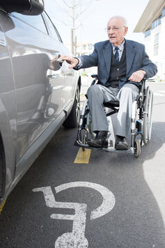elderly handicapped man opening the car door