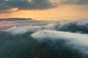 Aerial view fog in the forest and mountains and the transmission towers. Repeater station.