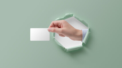 Hand in a paper hole holding a card