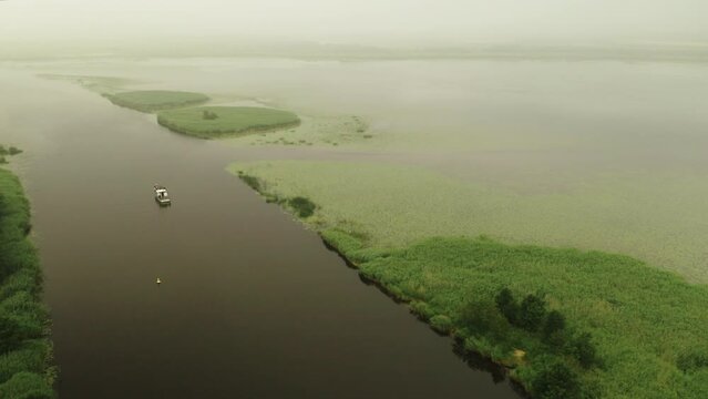 Aerial shot of ship exploring Nemunas Delta Regional Park. Lithuania. 4K 25fps