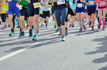 Marathon running race, many runners feet on road racing, sport competition, fitness and healthy lifestyle concept
