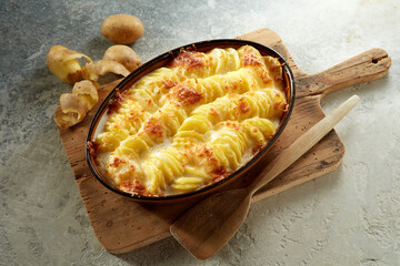 Delicious casserole with potato and cheese served on cutting board