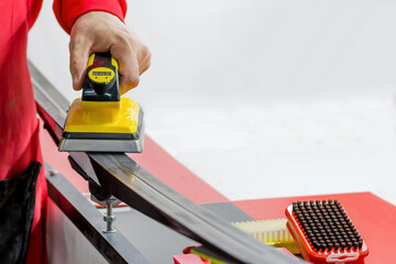 Preparation of cross-country skis. Application of paraffin ski lubricant with an iron to the...